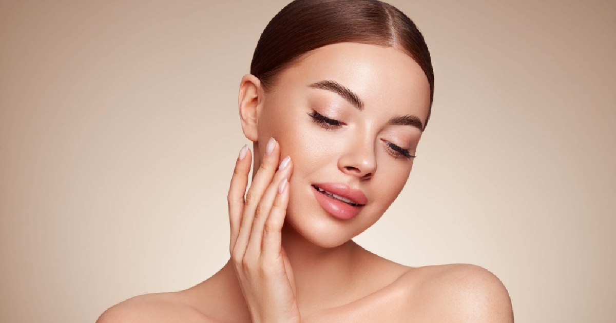 Close-up of a woman with smooth, radiant skin touching her face, showcasing results of Subnovii Plasma Pen in Lima, OH.