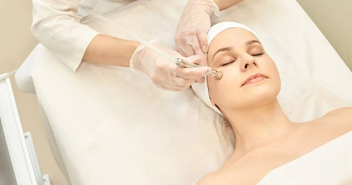 Aesthetician performing a Diamond Glow Facial on a woman in Lima, OH
